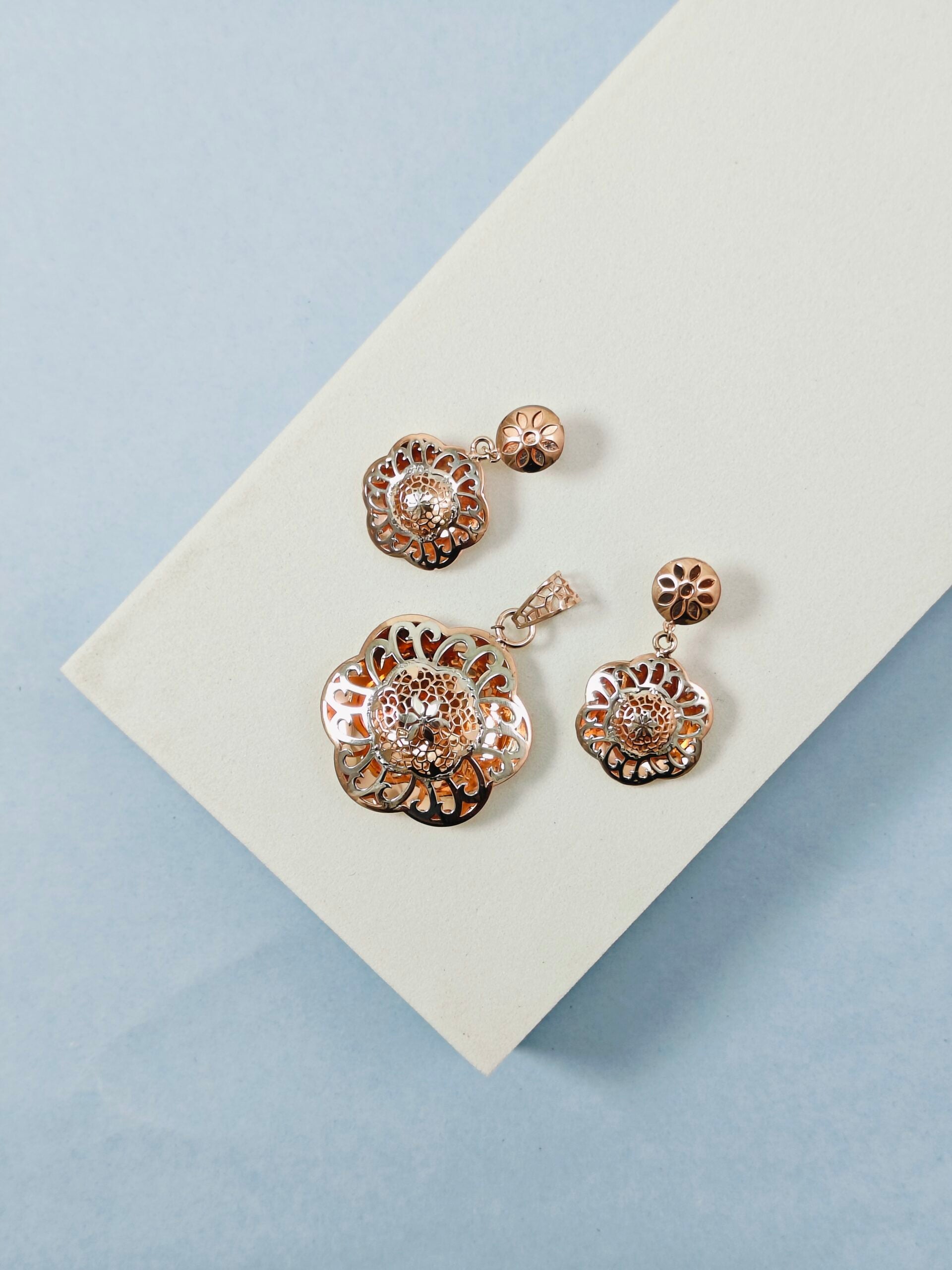 Set of floral earrings on a light blue background